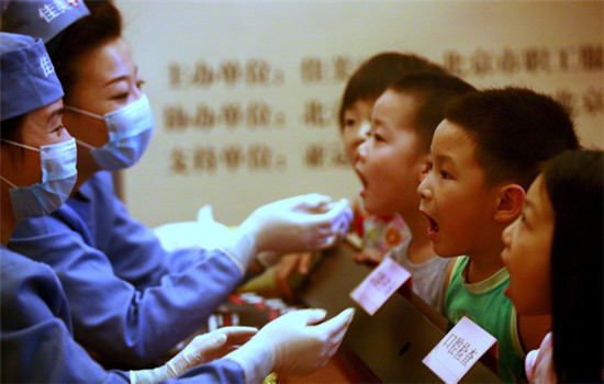 Dentists from Jiamei Dental Group offer free oral checkups for children in Beijing. (Photo by Hu Xuebai/For China Daily)