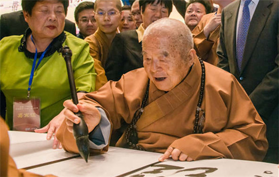 Hsing Yun, founder of the Fo Guang Shan Monastery in Taiwan, writes one verse of the Heart Sutra at the Nanjing forum. (Photo by Guo Shasha/Provided to China Daily)