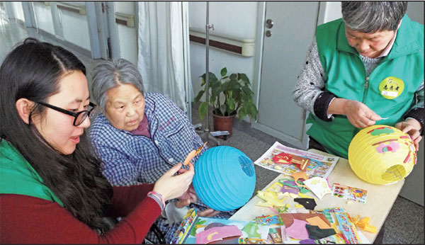 A patient in the oncology and hematology department of the Beijing Haidian Hospital makes paper lanterns in the company of volunteers from the Beijing Living Will Promotion Association.Ting Ting / For China Daily