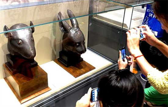 Visitors at the National Museum of China in Beijing view the bronze heads of a rabbit and a rat in 2013 that had been looted in 1890 and returned to China three years ago by a French businessman.(Li Xin/ Xinhua)