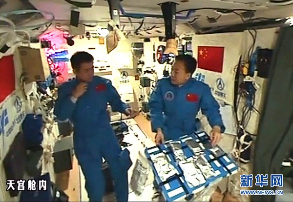Chinese astronaut Jing Haipeng (R) explains the meals they eat in space aboard Tiangong II, Nov 4, 2016. (Photo/Xinhua)