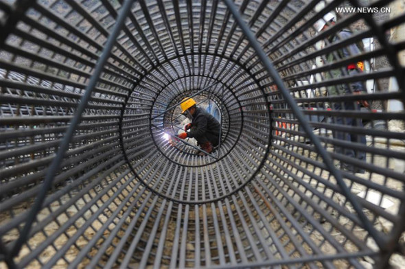 A worker welds steel reinforcement during construction of the Lhasa-Nyingchi segment of Sichuan-Tibet Railway in Nyingchi, southwest China's Tibet Autonomous Region, March 19, 2016. (Photo: Xinhua/Cao Ning)
