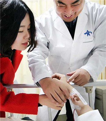 Guo Shuzhong, an expert in reconstructive surgery at the First Affiliated Hospital of Xi'an Jiaotong University, checks an ear grown on the arm of a patient, who lost his right ear in a car accident, on Wednesday.(Ruan Banhui/For China Daily)