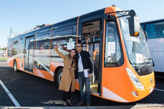 Two Moroccans take selfie with an electric bus from China in Marrakech, Morocco, Nov. 9, 2016. Over ten electric buses from China served the delegates during the 22nd Conference of Parties to the United Nations Framework Convention on Climate Change (COP22) in Marrakech. (PhotoXinhua/Meng Tao)