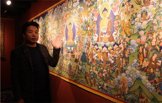 Kelsang Dawa shows his thangka collection at his painting center in Shangri-La, Yunnan province. The Tibetan art genre is energy-intensivesometimes it takes years to finish one piece. (WANG KAIHAO/CHINA DAILY)