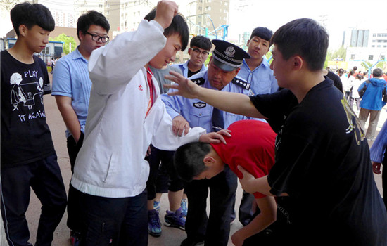 A police officer teaches students how to avoid being bullied during an awareness-raising class at a middle school in Shenyang, Liaoning province. (Photo by ZHAO JINGDONG/CHINA DAILY)