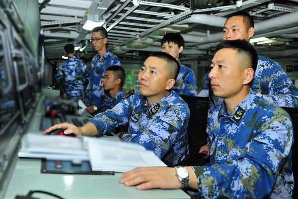 Huang Aijian (second from right), an officer with the electrical and mechanical squadron on the carrier, is on duty with his subordinates. (Photo/GT)