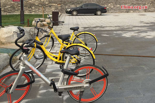 A Mobike is parked next to two Ofo bikes. (Photo/ China.org.cn)