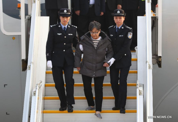 Yang Xiuzhu (C) is escorted at Beijing Capital International Airport in Beijing, capital of China, Nov. 16, 2016. China's most wanted fugitive Yang Xiuzhu, who had been on the run for 13 years, returned to China Wednesday and turned herself in to the authorities, according to the Communist Party of China's disciplinary watchdog. (Photo/Xinhua)