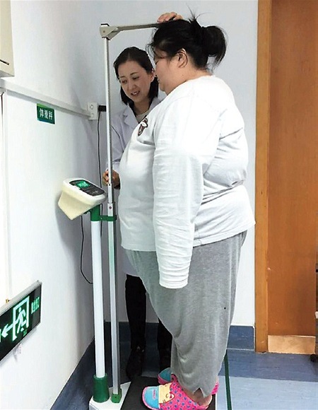 Nurse Chen Lihua checks Zhus weight and height before the surgery.(Photo/Shanghai Daily)