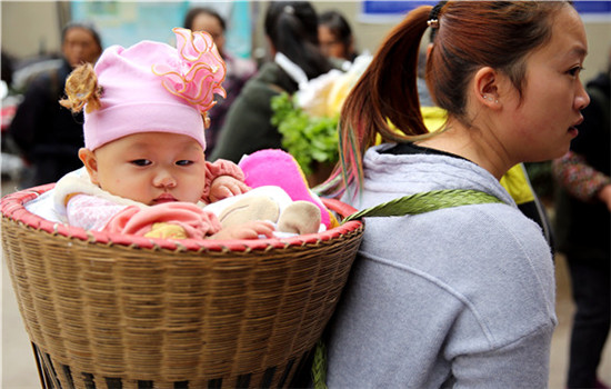 A woman carries her baby to the newly built market in Moudao.