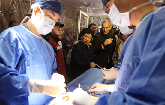 Margaret Chan, WHO director-general, watches a simulation surgery during her visit to a Shanghai-based emergency rescue team on Tuesday. (Photo by Gao Erqiang/China Daily)