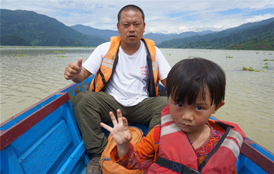 Pan Zhenwen and her father, Pan Tufeng, travel by boat during a trip to Pokhara, Nepal, in August. (Provided to CHINA DAILY)