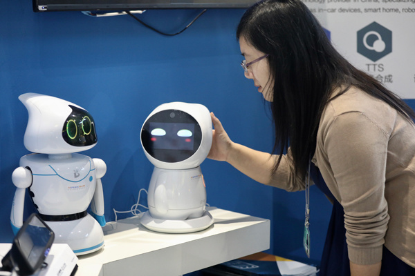 A visitor interacts with robots at the Third International Internet Forum in Wuzhen, Zhejiang province, on Nov 15, 2016. ZHU XINGXIN / CHINA DAILY