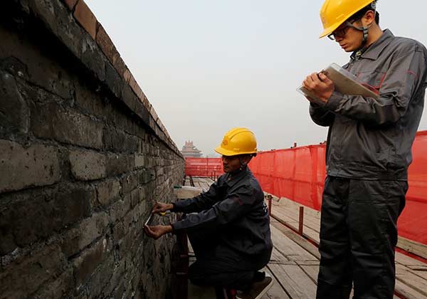 Workers take measurements on Saturday as they prepare for restoration of the walls of the Palace Museum in Beijing. JIANG DONG/CHINA DAILY