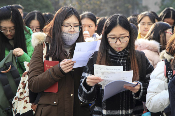 Test-takers check their notes at Nanjing Forestry University in Jiangsu province before the national civil service exam begins on Sunday. (Photo: China Daily/Liu Jiahua)