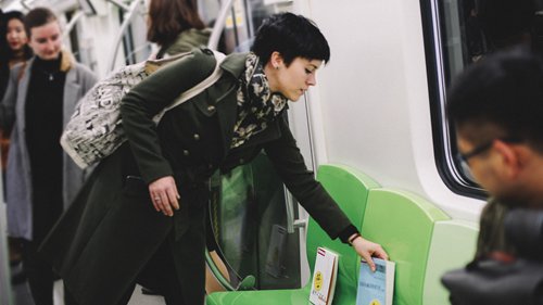 Cordelia Oxley places books on the Beijing Subway on Saturday. (Photo/Courtesy of The Fair)