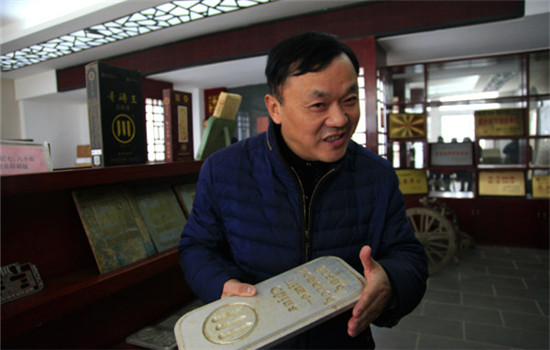 Gan Duoping, the fourth generation inheritor of Zhaoliqiao brick tea production techniques, introduces brick tea production techniques at Zhaoliqiao Tea Factory in Chibi, Central China's Hubei province, on November 29, 2016. (Photo by Zhu Lingqing/chinadaily.com.cn)
