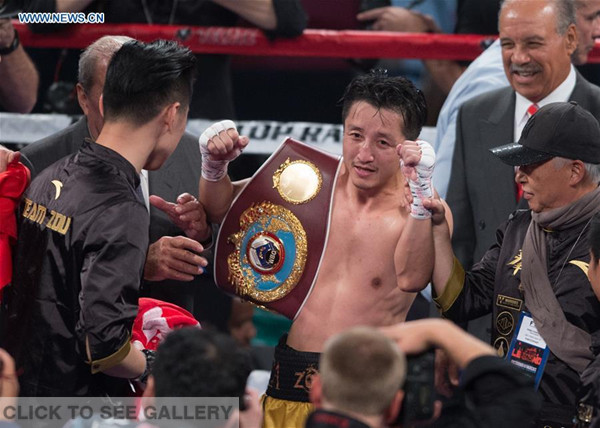 Zou Shiming (C) of China celebrates after defeating Prasitak Phaprom of Thailand in a WBO flyweight title boxing match in Las Vegas, the United States, Nov. 5, 2016. (Photo/Xinhua)
