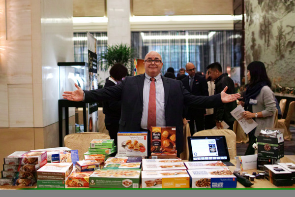 A business representative presents microwave food products made in Canada. (Photo: Guo Sheng/Provided to Ecns.cn)