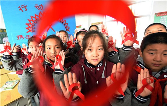 Elementary school students in Donghai county in Jiangsu province crafted red ribbons as part of an HIV/AIDS prevention campaign on Tuesday. (ZHANG ZHENGYOU / FOR CHINA DAILY)