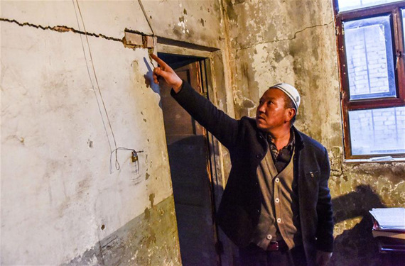 Ma Zhonghai evaluates the damage caused by an earthquake to his house at Queergou Town in Hutubi County, northwest China's Xinjiang Uygur Autonomous Region, Dec. 8, 2016.(Photo: Xinhua/Zhao Ge)