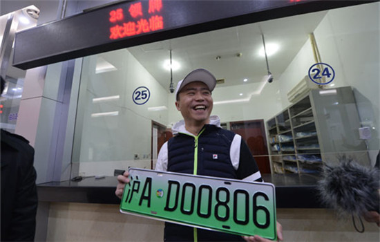Wu Feng, owner of a Tesla Model X, is the first to install the new plate in Shanghai, on Dec 1, 2016. (Photo provided to chinadaily.com.cn)