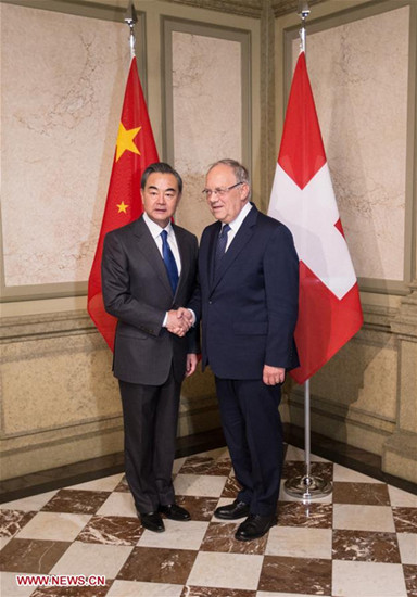 Chinese Foreign Minister Wang Yi (L) shakes hands with Swiss President Johann Schneider-Ammann in Bern, Switzerland, on Dec. 12, 2016. (Xinhua/Xu Jinquan)