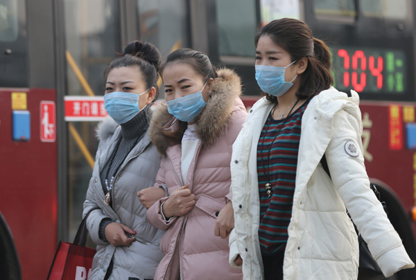 People wear masks in Xi'an, Shaanxi province, on Tuesday, the fifth consecutive day of serious air pollution. Provided To China Daily
