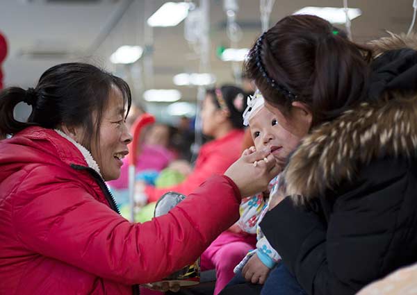 A child is given an intravenous infusion at the Beijing Children's Hospital on Wednesday. Many children have recently been found exhibiting symptoms of respiratory illness, partly due to frequent smoggy days and significant changes in temperature.Ding Shan / For China Daily