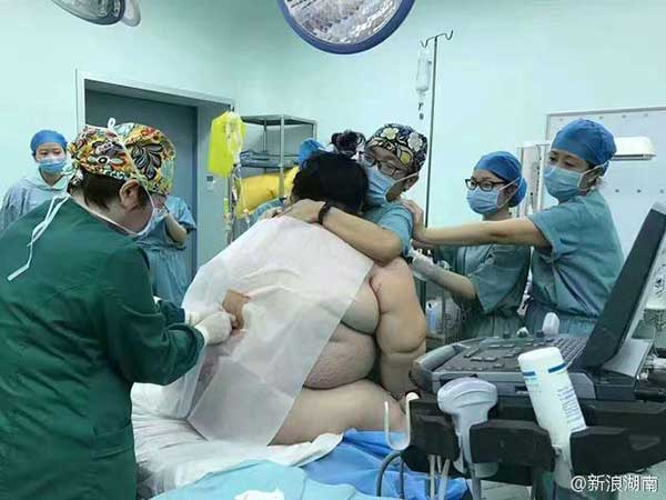 Medical staff members help the woman deliver the baby. (Photo from Sina Weibo)
