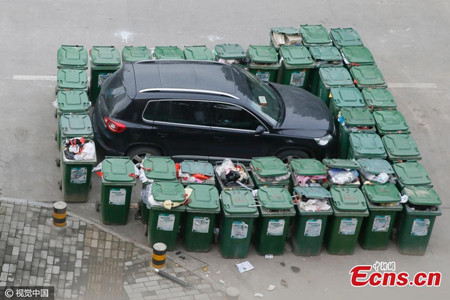 A SUV is surrounded by large trash containers for illegally parking at an intersection in Hefei, Anhui Province on Dec. 17, 2016. The janitor who encircled the vehicle said parking at this intersection is illegal as it is used as a garbage station and fire channel, and that the owner could not be reached. (Photo/CFP)