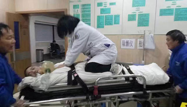 A doctor offering closed-chest cardiac massage on a patient while kneeling down on a quick moving stretcher in Hangzhou, Zhejiang Province.(Photo from web)
