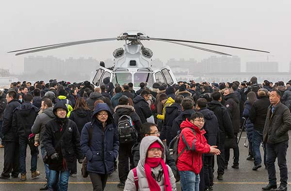 People take a close look at the AC352 utility helicopter after it finished its maiden flight in Harbin, Heilongjiang province, on Tuesday.(Photo/China Daily)