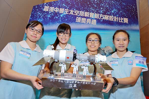 Students from a Hong Kong secondary school celebrate winning second prize at the Space Science Experiment Competition for their experiment to breed silkworms in space. They were presented with a model of Shenzhou XI docked with the Tiangong II space lab. (Photo/China Daily)