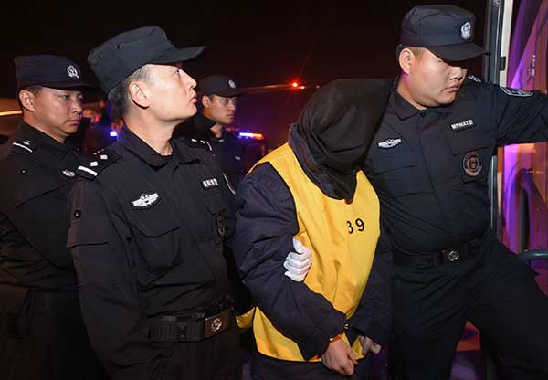 Seventy-four suspects are brought back to Wuhan, Hubei province, in November after Chinese and Malaysian police cracked a telecom fraud case. (Photo/Xinhua)