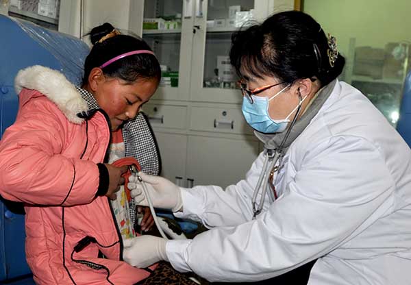 Yu Yabin, a pediatrician from Beijing Obstetrics and Gynecology Hospital, conducts a health check on a Tibetan girl. (PALDEN NYIMA/CHINA DAILY)