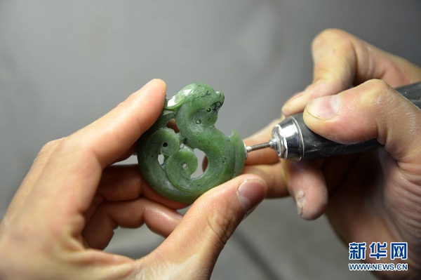 A carver utilizes a special gadget to cut a piece of Gobi jade into an antique-style dragon at a local antique store in Urad Middle Banner, Inner Mongolia autonomous region. Often found in the Urad grassland, this type of Gobi jade is especially hard, very smooth, and can be polished to a high gloss. These Gobi jades are usually carved into various shapes including animals, flowers, plants, and human figures. With the extraordinary folk workmanship, these vivid and lifelike handicrafts are not only part of the regions heritage and historic culture but also benefit local craftsmen and jade merchants. (Photo/Xinhua)