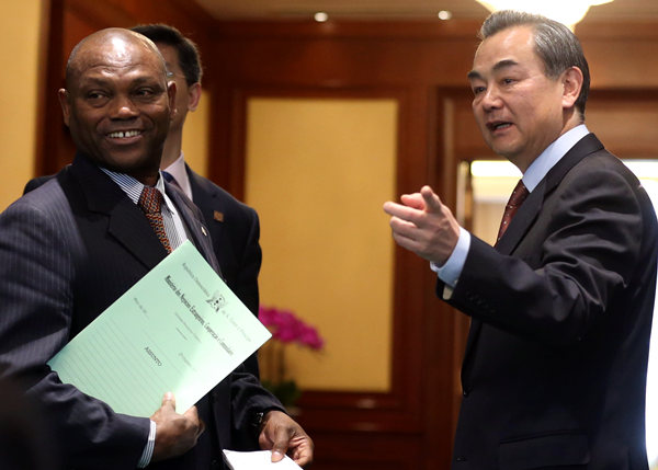 Foreign Minister Wang Yi and Urbino Botelho, his counterpart from the African island nation of Sao Tome and Principe, share a light moment before they meet journalists in Beijing on Monday to discuss the nations' resumption of diplomatic relations. Feng Yongbin / China Daily
