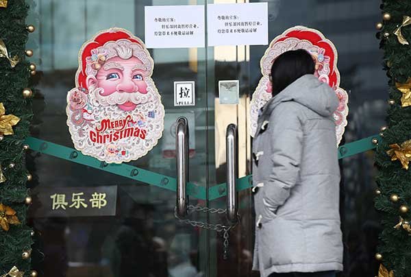 A notice at the entrance of Baoli Club in Beijing's Chaoyang district says it has suspended business. Liu Chang / For China Daily