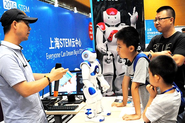 Kids and parents interact with a smart robot during the First International STEM Science Festival held in July 2016 in Suzhou, Jiangsu province. (Photo/China Daily)