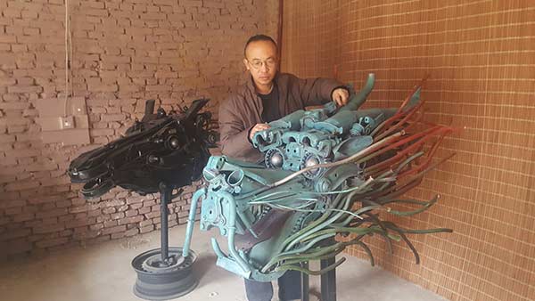 Huang Qicai with one of his favorite works, Dragon Head, at his studio in a southern suburb of Taiyuan, Shanxi province. SUN RUISHENG/CHINA DAILY
