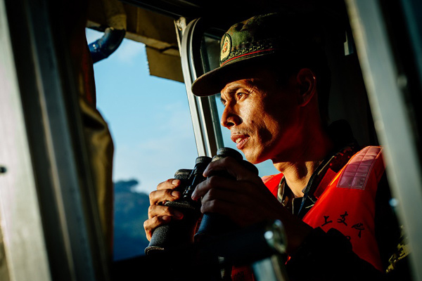 Tan Jianhua watches traffic during a patrol drill. Photo By Qian Cheng / For China Daily