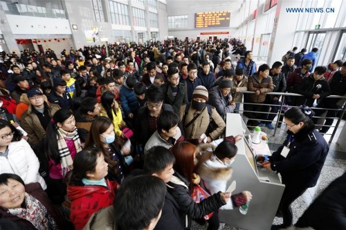 Passengers prepare to have tickets checked at a passenger station in Lianyungang, east China's Jiangsu Province, Feb. 13, 2016. (Photo: Xinhua/Si Wei)