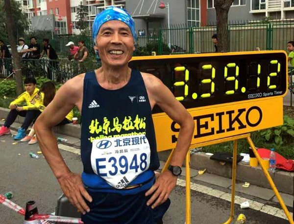Feng Kaichen, 64, with his finishing time after a marathon in Beijing. (Photo provided to China Daily)