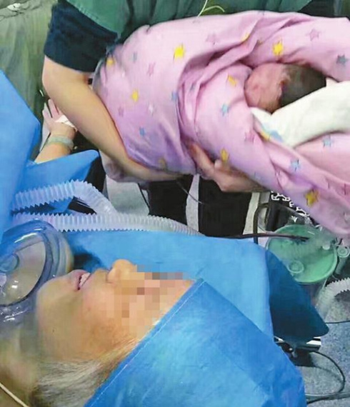 The 64-year-old woman looks at her baby in the delivery room of the Second Hospital of Jilin University, in Changchun, Jilin province, Dec 28, 2016. (Photo/Sina Weibo)