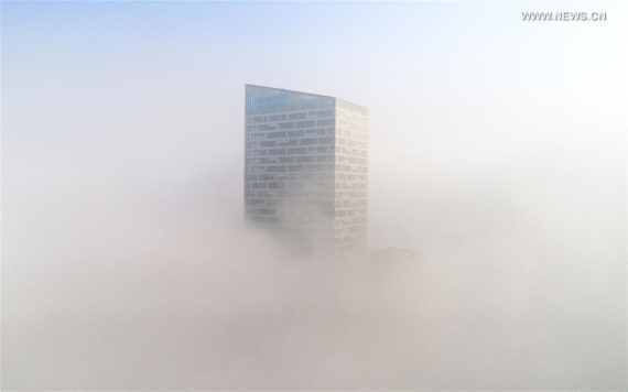Photo taken on Jan. 3, 2017 shows a fog-bound building in Hefei, capital of east China's Anhui Province. A red alert for fog in large parts of China was issued by the National Meteorological Center on Tuesday. (Photo: Xinhua/Guo Chen) 