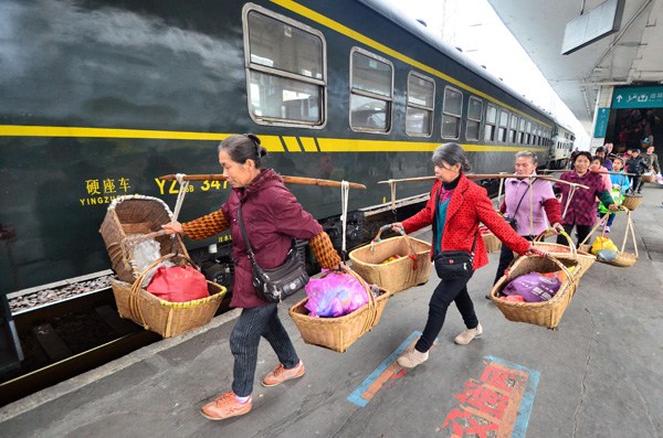Vegetable farmers prepare to board a train in Chenzhou, Hunan province, late last month. He Maofeng/For China Daily