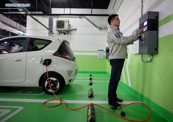 A working staff from Shanghai electricity company tests a charging post in Shanghai, east China, May 28, 2014.  (Photo/Xinhua/Ding Ting)