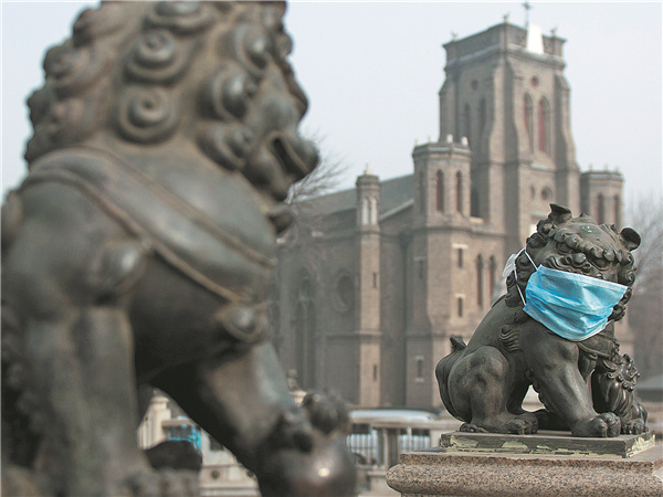A stone lion on a bridge in Tianjin is covered with a mask in the heavy smog that has hit much of the country's northern regions. (Photo by TONG YU For China Daily)